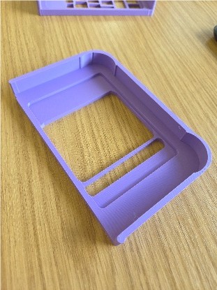 Purple plastic keyguard sitting on a wooden surface.