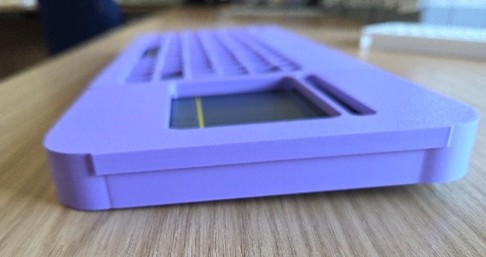 Purple plastic keyguard on a keyboard sitting on a wooden surface.
